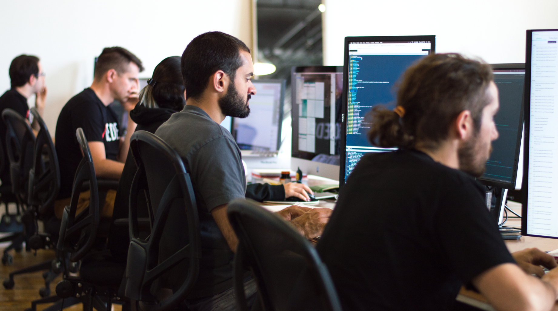 Programmeurs et designer web travaillant à leur bureau 