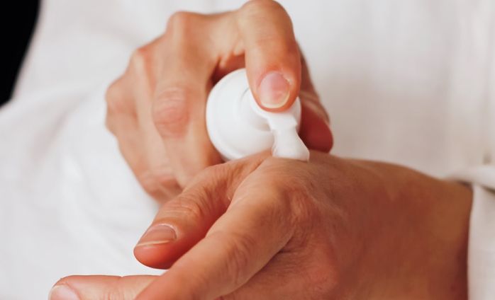A person applying a moisturizing foam on his hands 