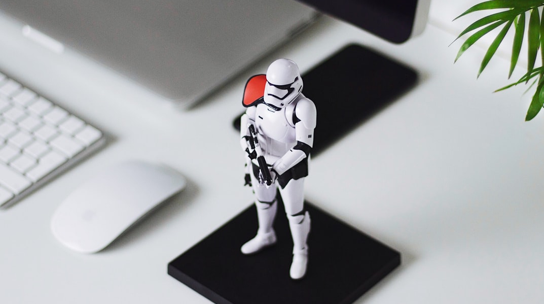 Star Wars Stormtrooper on a desk next to a computer 